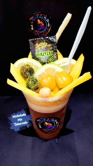Mixchelada de tamarindo decorada con mango, limón y dulces